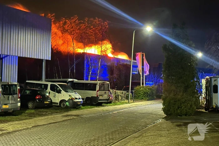 Vlammen slaan uit dak van gebouw