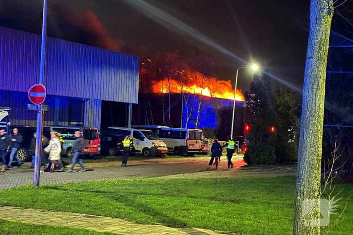 Vlammen slaan uit dak van gebouw
