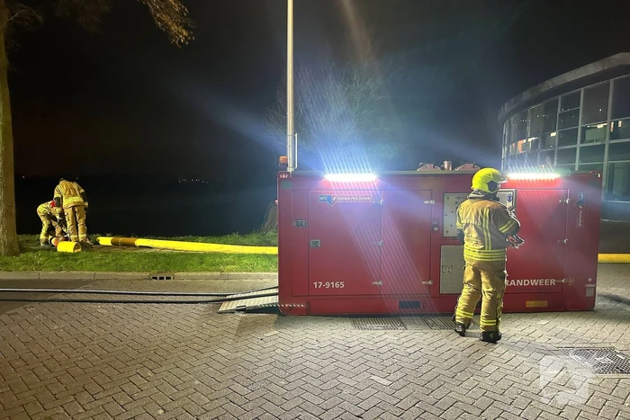 Vlammen slaan uit dak van gebouw