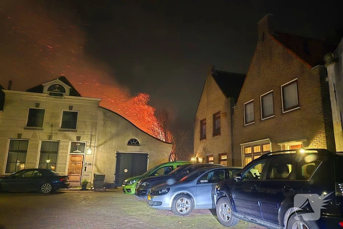 Brandende coniferen haag met tuinslangen geblust