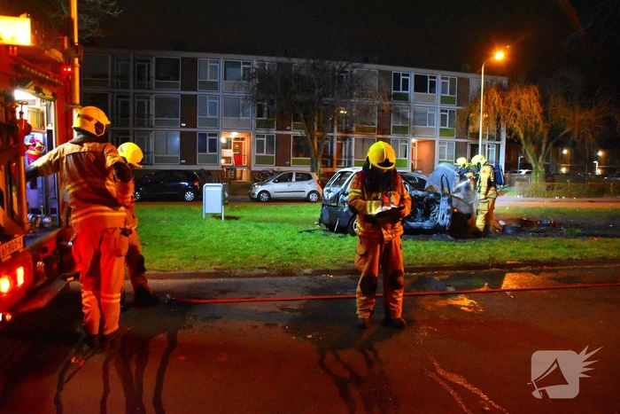 Auto in brand gestoken op grasveld