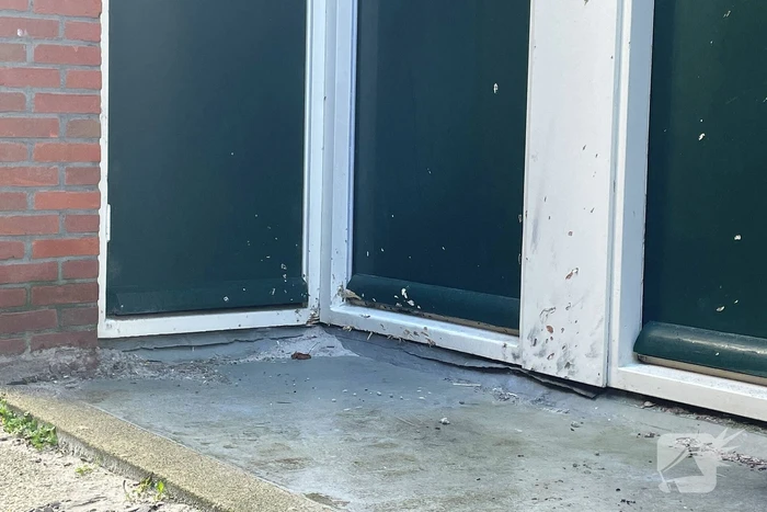 Voordeur van een woning beschadigd door een explosief