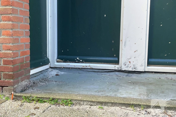 Voordeur van een woning beschadigd door een explosief