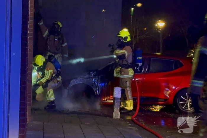 Auto brandt uit tegen gevel van flatgebouw