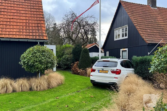 Automobiliste raakt van de weg en rijdt tuin in