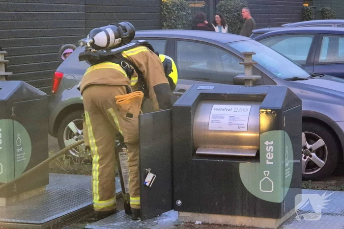 Brandweer dooft brand in ondergrondse vuilcontainer