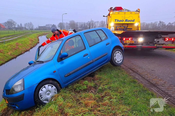 Auto te water door modderig wegdek