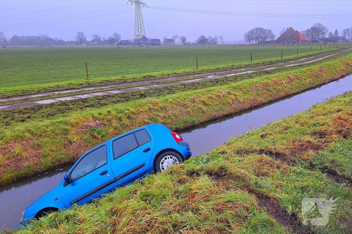 Auto te water door modderig wegdek