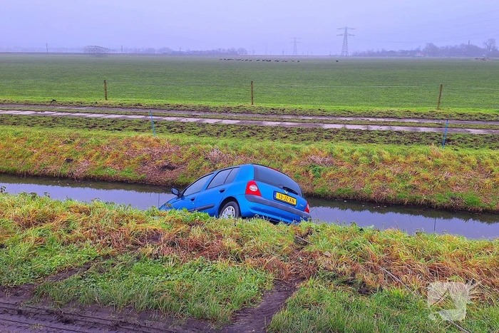 Auto te water door modderig wegdek