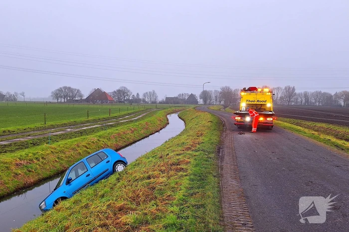 Auto te water door modderig wegdek