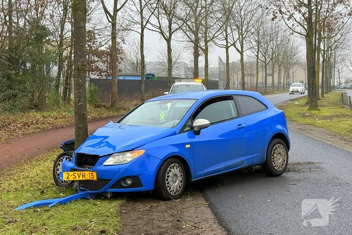 Auto knalt tegen boom in bocht