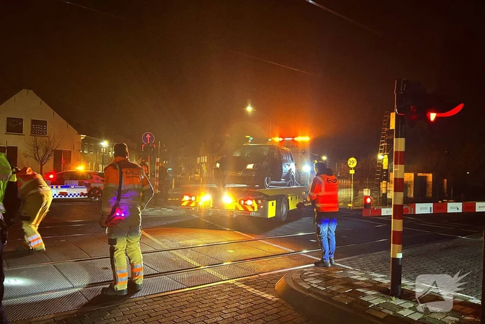 Auto geramd door trein op spoorwegovergang