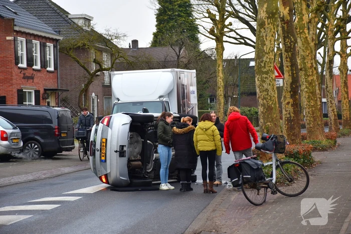 Bestuurster raakt boom, auto belandt op zijkant
