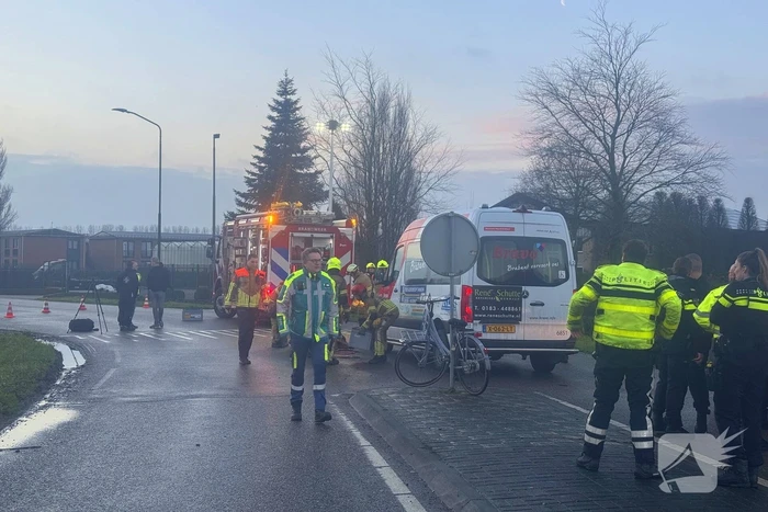 Fietser vast onder buurtbus