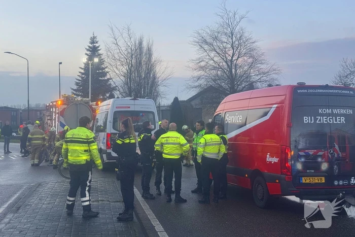 Fietser vast onder buurtbus