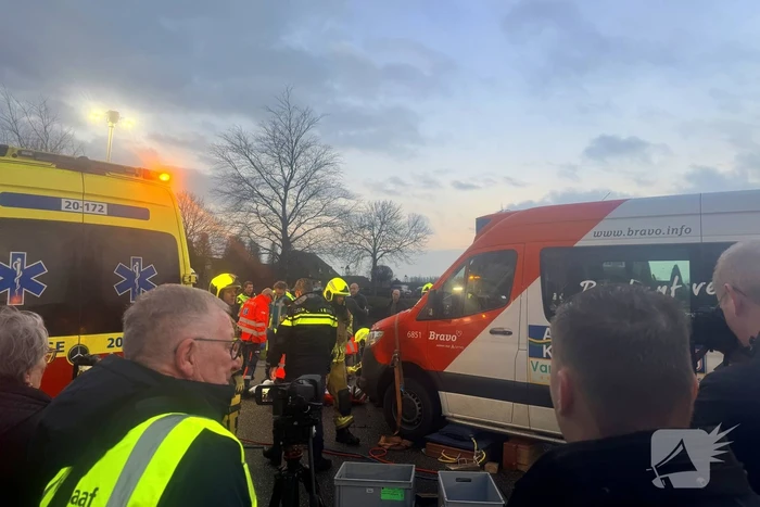 Fietser vast onder buurtbus