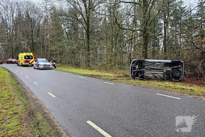 Auto belandt op zijkant naast weg