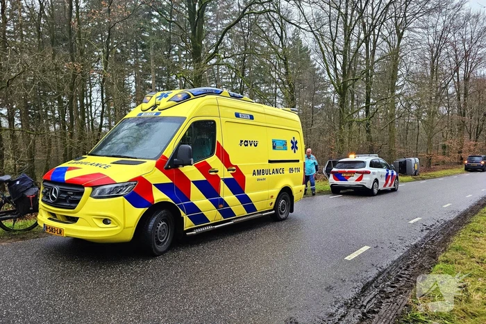 Auto belandt op zijkant naast weg