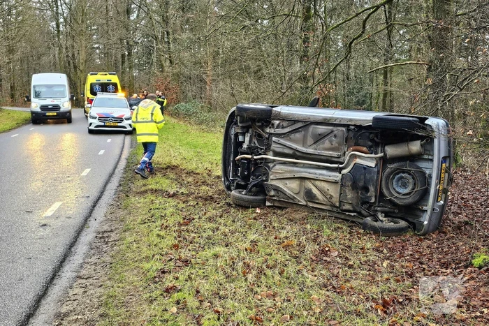 Auto belandt op zijkant naast weg