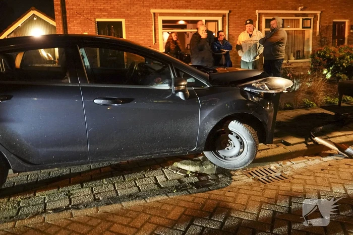Automobilist ramt lantaarnpaal en kleine paal