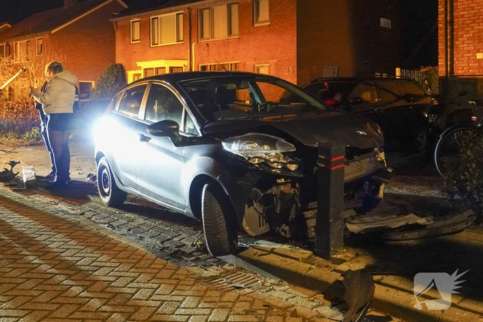 Automobilist ramt lantaarnpaal en kleine paal