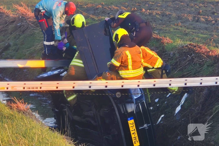 Voertuig belandt op zijkant in water na ongeval