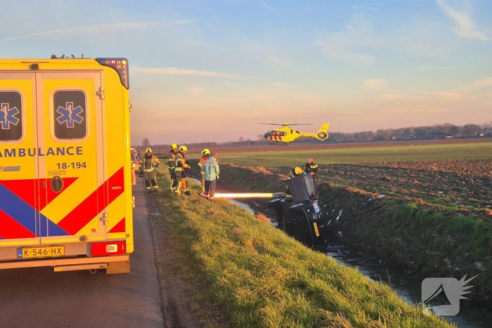 Voertuig belandt op zijkant in water na ongeval
