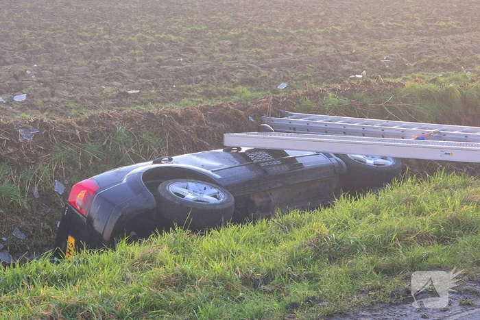 Voertuig belandt op zijkant in water na ongeval