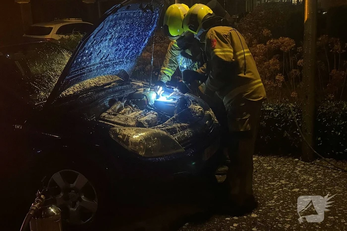 Brand onder motorkap van auto