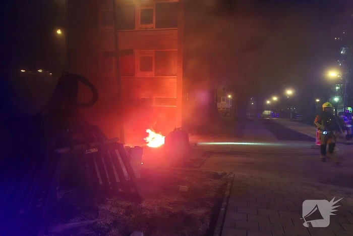 Veel rook bij buitenbrand naast portiek