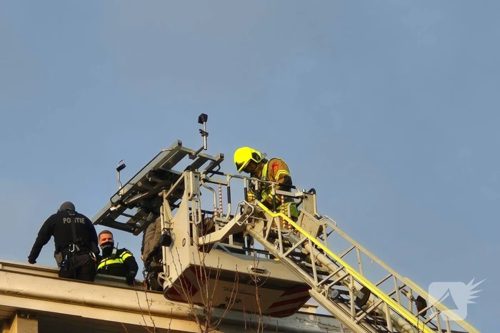 Man gooit voorwerpen van dak, politie team haalt man van dak