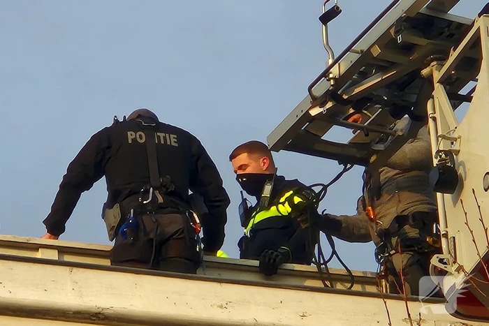 Man gooit voorwerpen van dak, politie team haalt man van dak