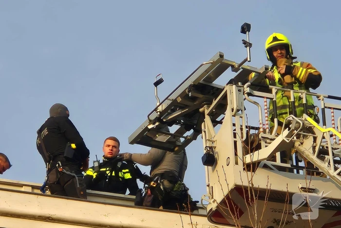 Man gooit voorwerpen van dak, politie team haalt man van dak