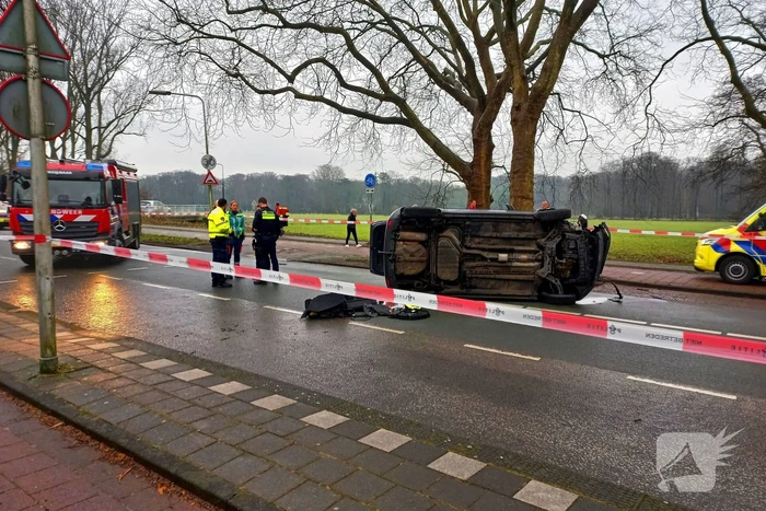 Auto belandt op zijn kant na botsing tegen boom
