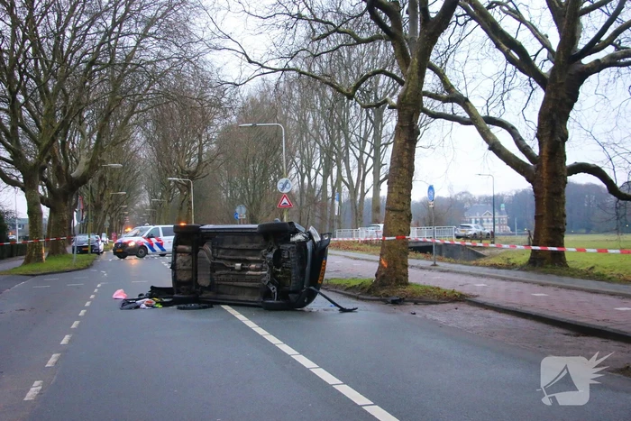 Auto belandt op zijn kant na botsing tegen boom