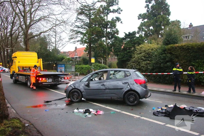 Auto belandt op zijn kant na botsing tegen boom