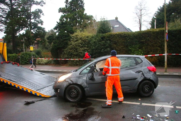 Auto belandt op zijn kant na botsing tegen boom
