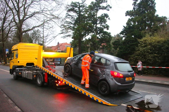 Auto belandt op zijn kant na botsing tegen boom