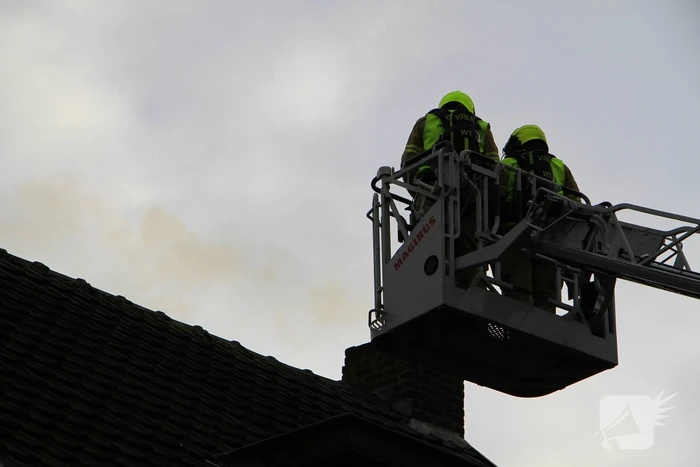Brandweer controleer schoorsteen na brand