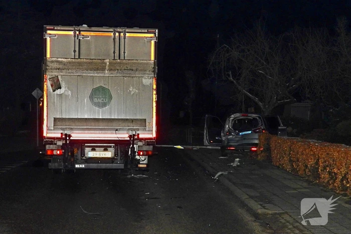 Taxi belandt in heg na botsing met vrachtwagen