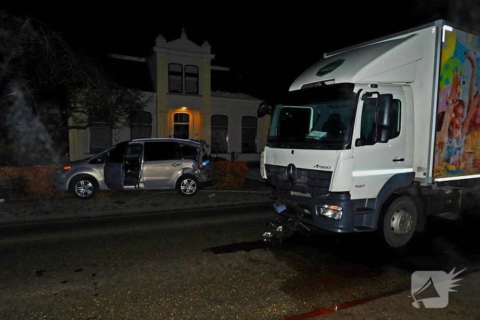 Taxi belandt in heg na botsing met vrachtwagen