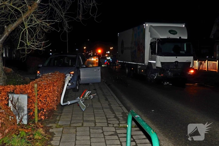 Taxi belandt in heg na botsing met vrachtwagen