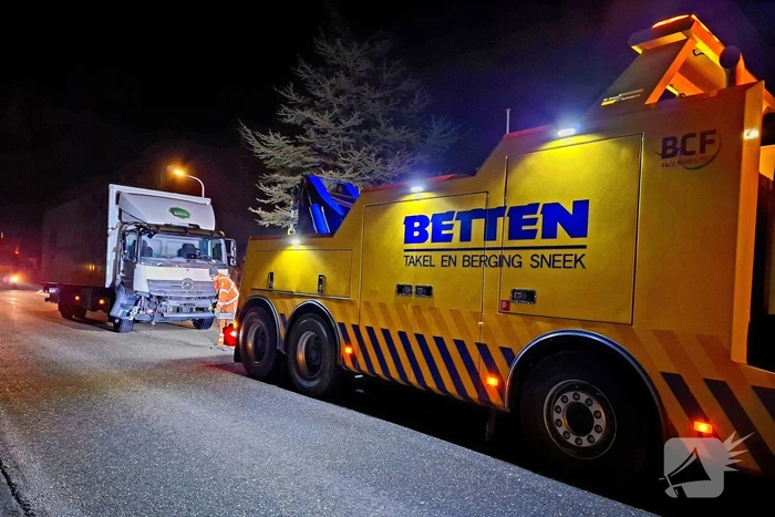 Taxi belandt in heg na botsing met vrachtwagen
