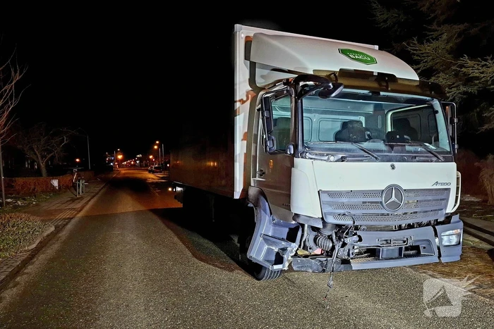 Taxi belandt in heg na botsing met vrachtwagen
