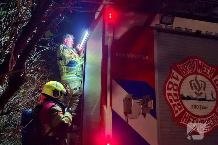 Vlammen slaan uit aanhanger, buurtbewoner start blussing