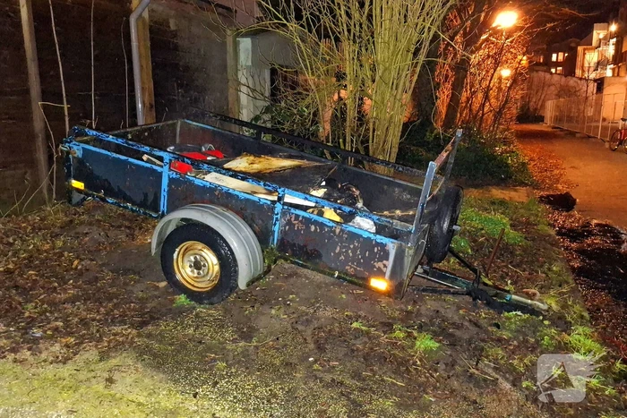 Vlammen slaan uit aanhanger, buurtbewoner start blussing