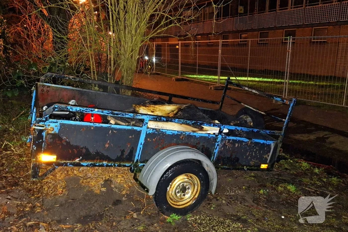 Vlammen slaan uit aanhanger, buurtbewoner start blussing