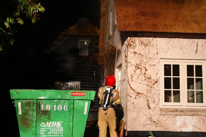 Bouwcontainer vat vlam naast woning met rietendak