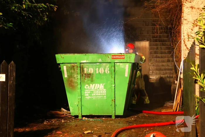 Bouwcontainer vat vlam naast woning met rietendak