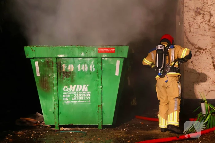 Bouwcontainer vat vlam naast woning met rietendak